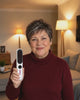Femme qui brosse sa frange vers l'arrière avec la brosse lissante sans fil ToneaGlow blanche