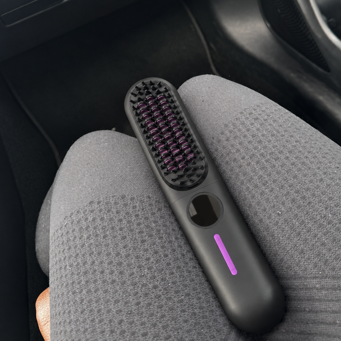 Brosse lissante sans fil ToneaGlow noire sur des jambes en legging gris