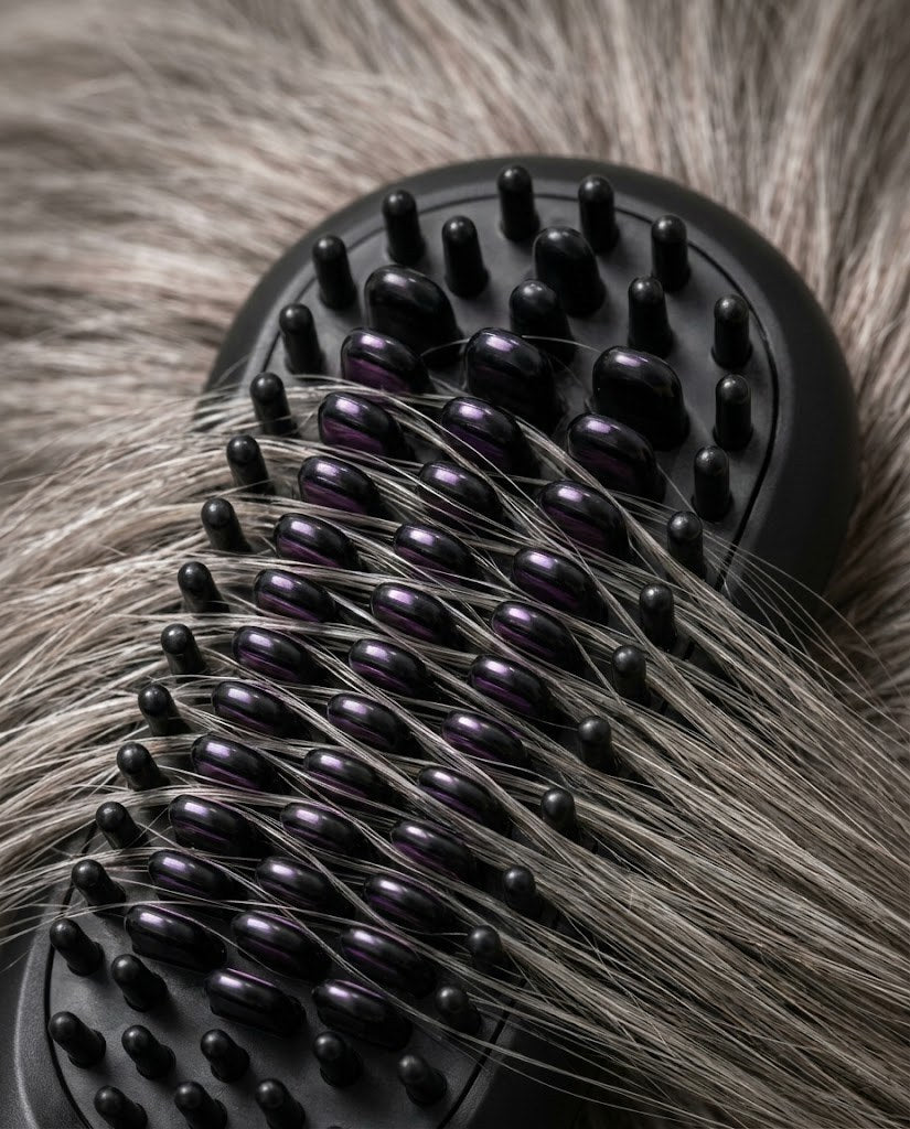 Gros plan des picots de la brosse contre des cheveux gris